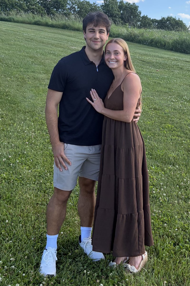 Billy and Chelsea Carlisle standing together in a green field